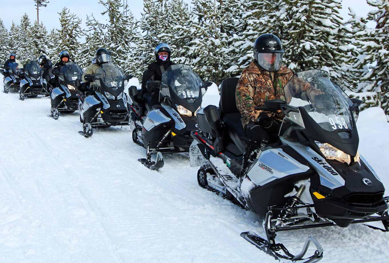 A group of snowmobile riders on a guided tour through Yellowstone National Park