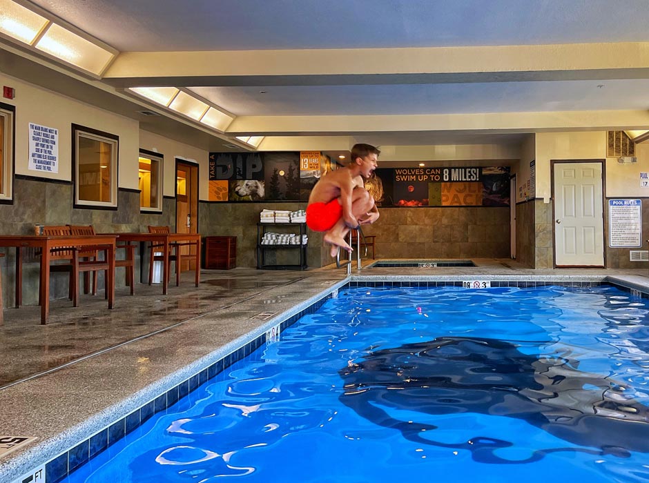 A guest at Gray Wolf Inn & Suites jumping into the indoor pool
