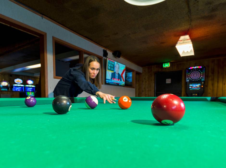 A guest shooting pool at the Ridgeline Hotel at Yellowstone
