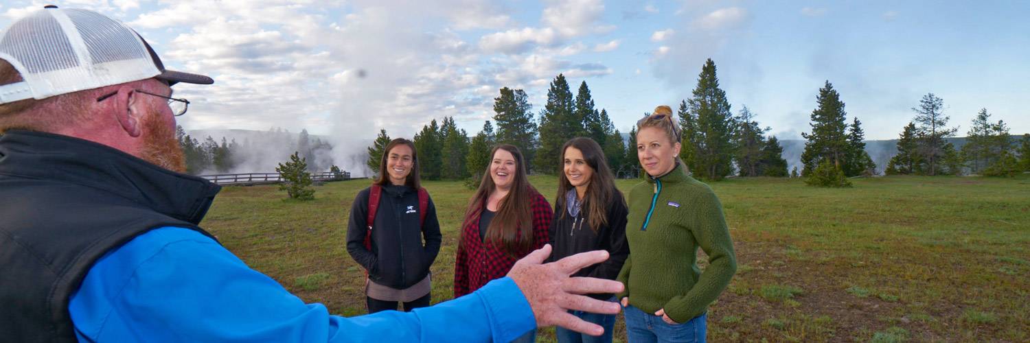 Four Yellowstone tourists getting an interpretive talk from a Yellowstone Vacations guide