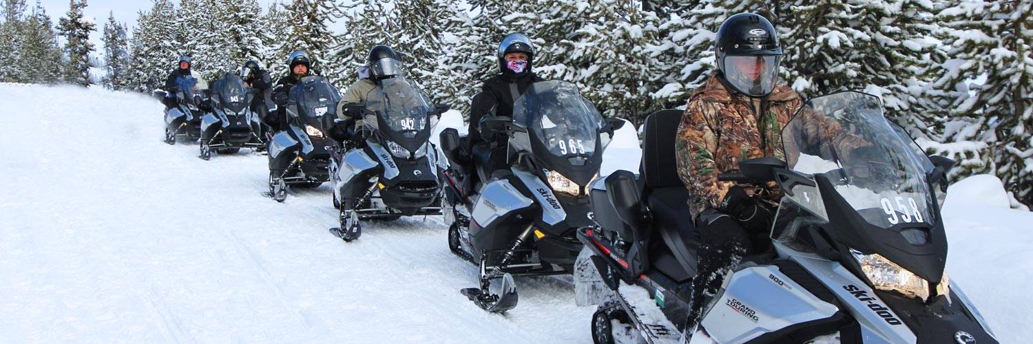 A group of snowmobile riders on a guided tour of Yellowstone National Park