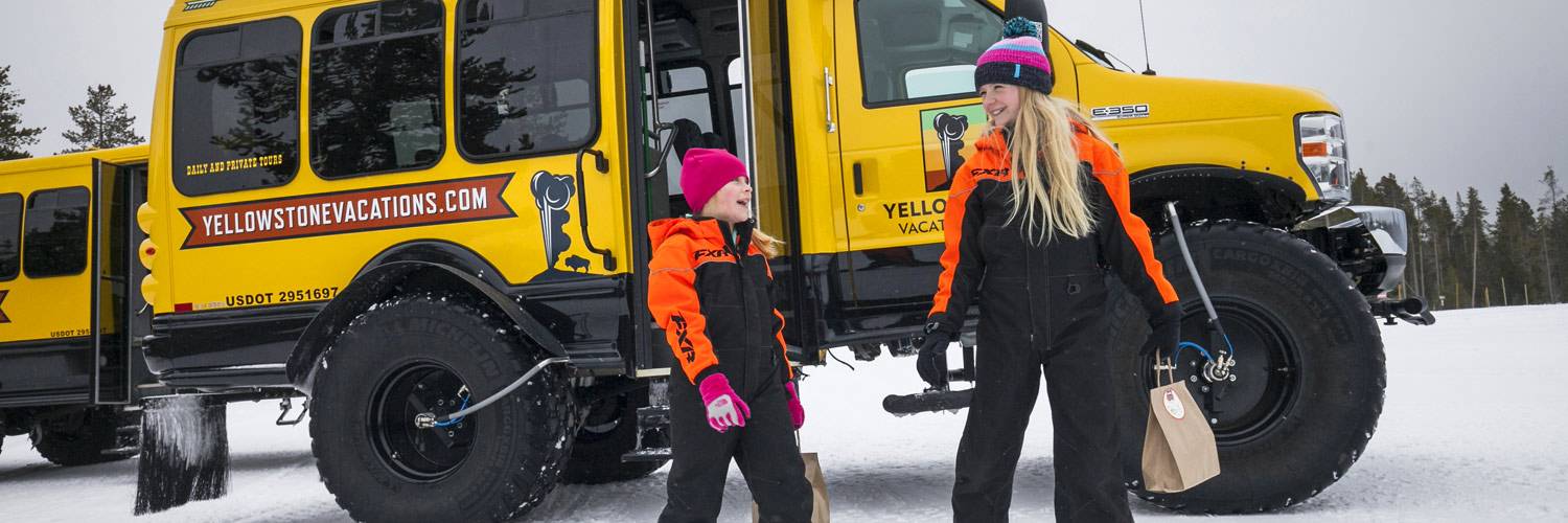 Two kids enjoying a snowcoach tour at Yellowstone Vacations.