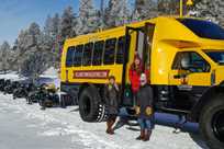 Three snowcoach riders pause for a photo during their Yellowstone tour