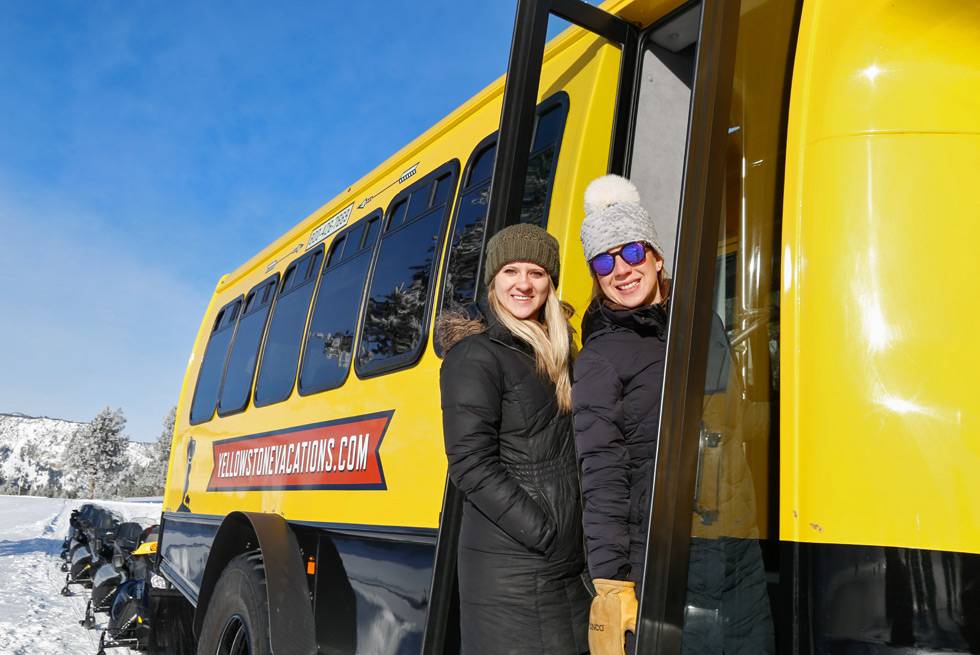 Two Yellowstone snowcoach passengers pause for a photo