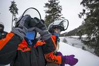 Kids using binoculars during a Yellowstone snowmobile tour