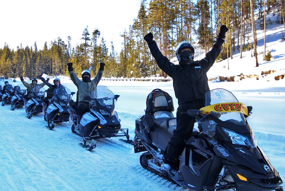 An excited group of Yellowstone snowmobile riders with their guide